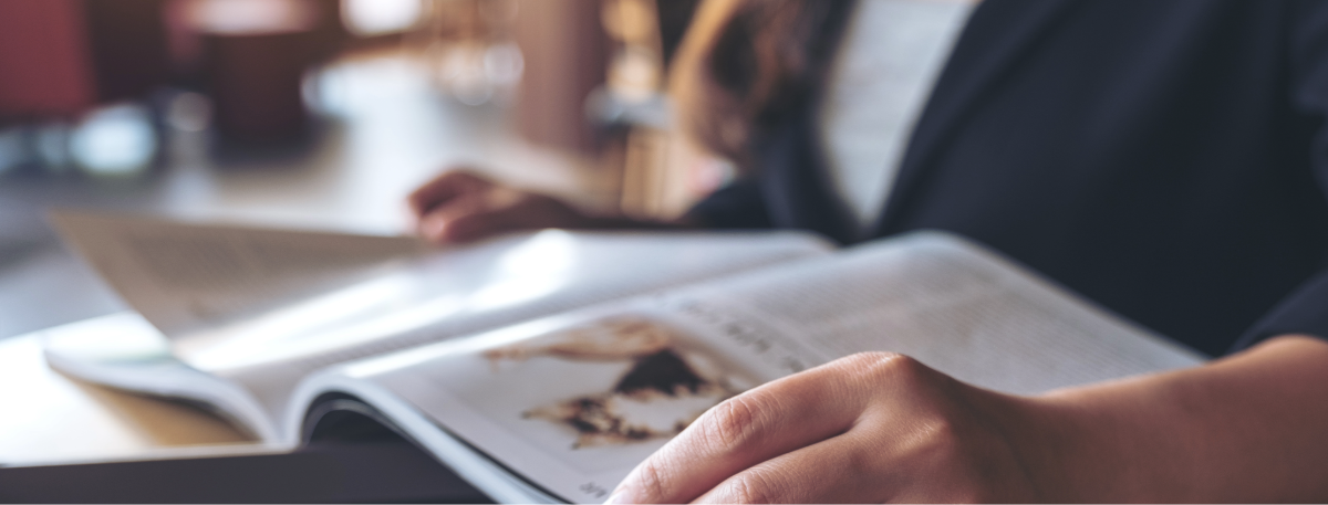 someone sitting down reading a newspaper article, in the press