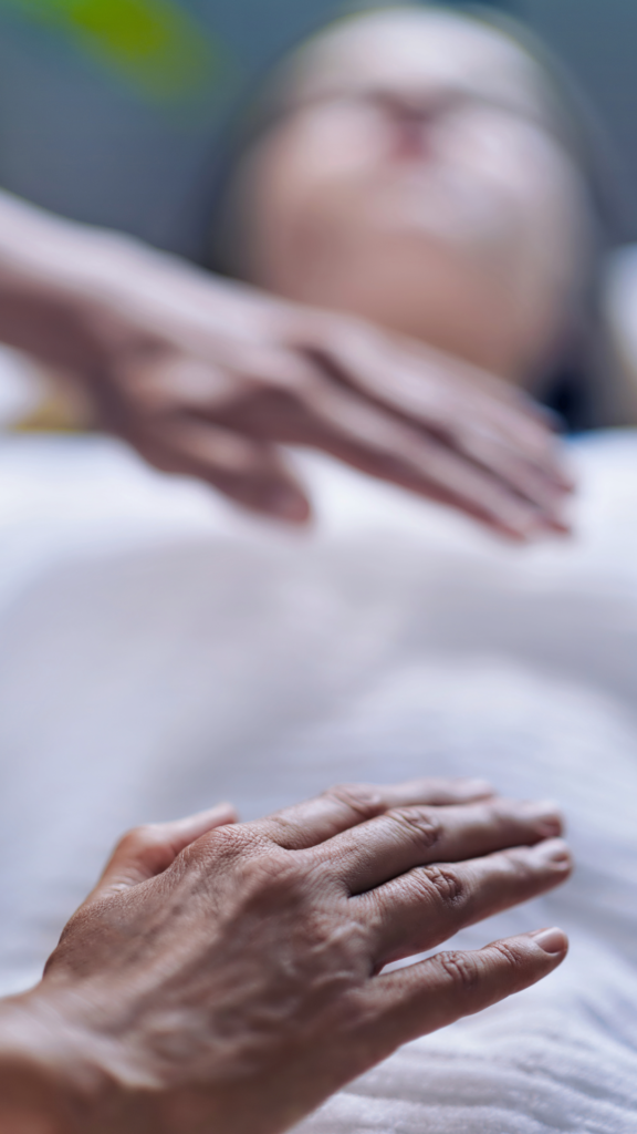 Reiki master hovering hands over patient, shallow depth of field
